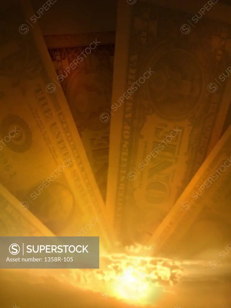 Paper money superimposed over a sunrise