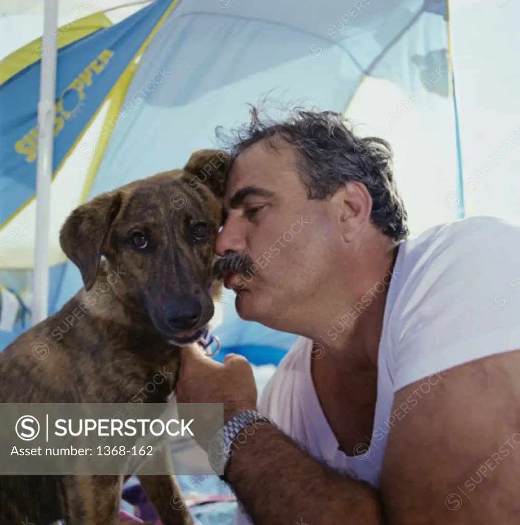 Close-up of a mature man kissing his dog