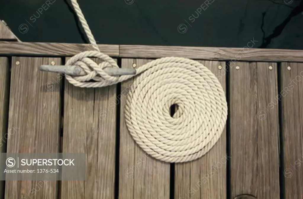 High angle view of a coiled rope tied to a cleat on a dock
