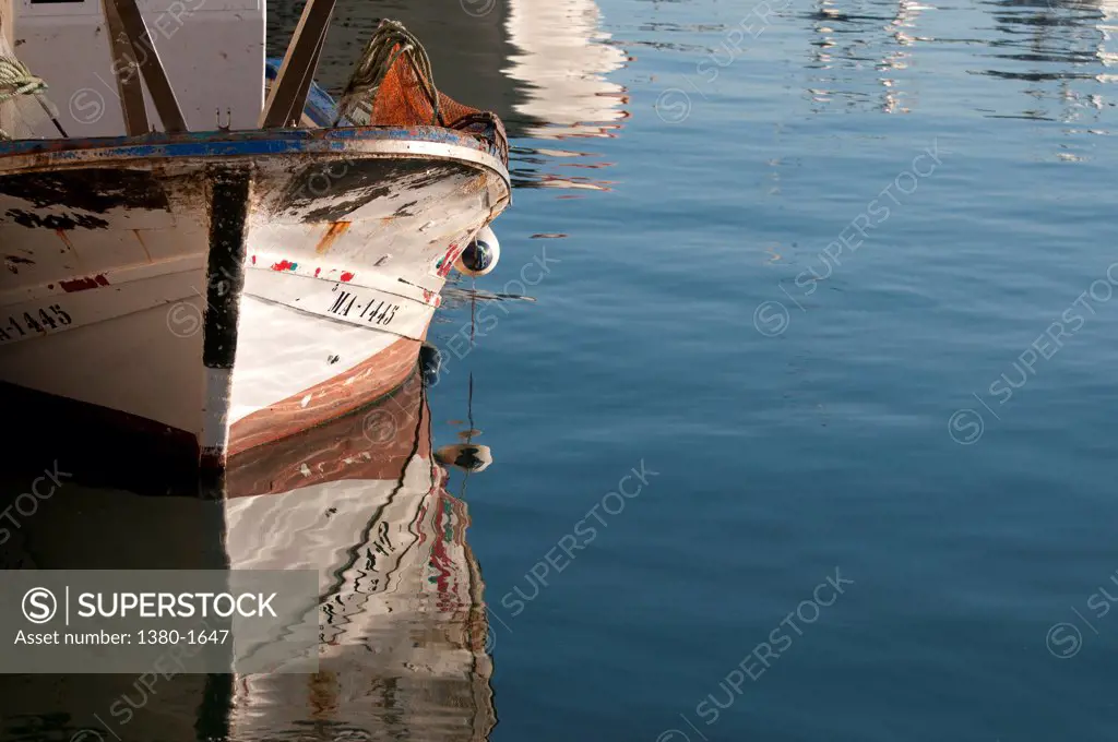 Reflection of fishing boat on water, Estepona, Malaga Province, Andalucia, Spain
