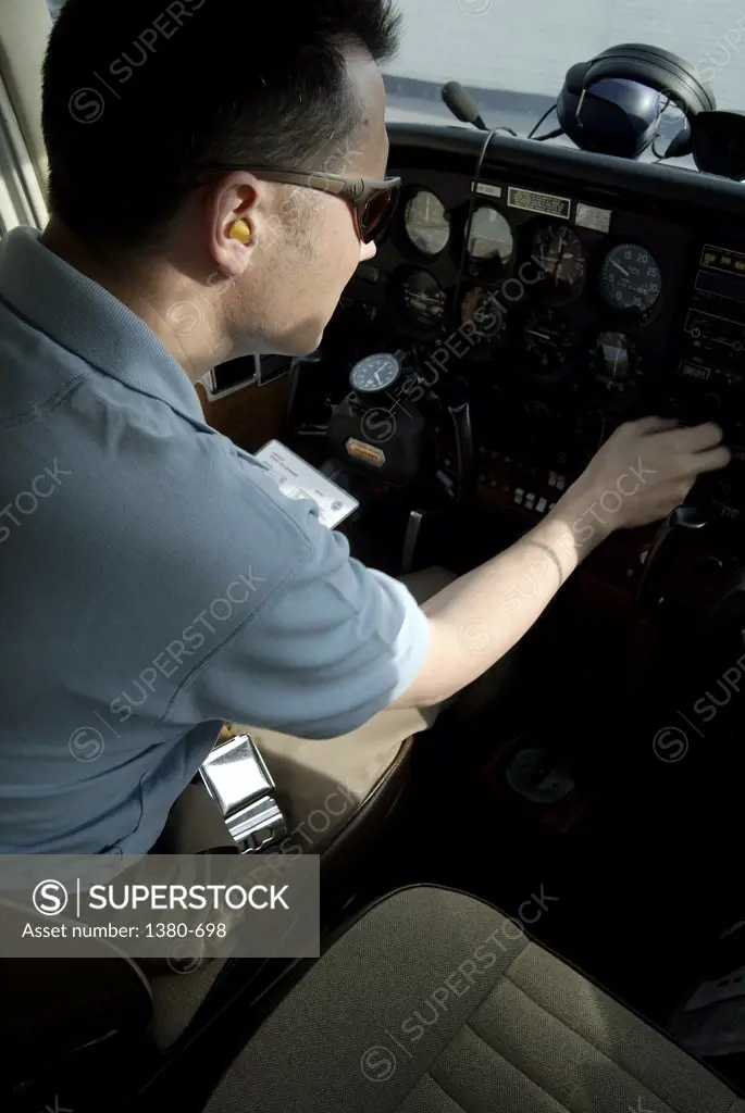 Rear view of a pilot in the cockpit of an airplane