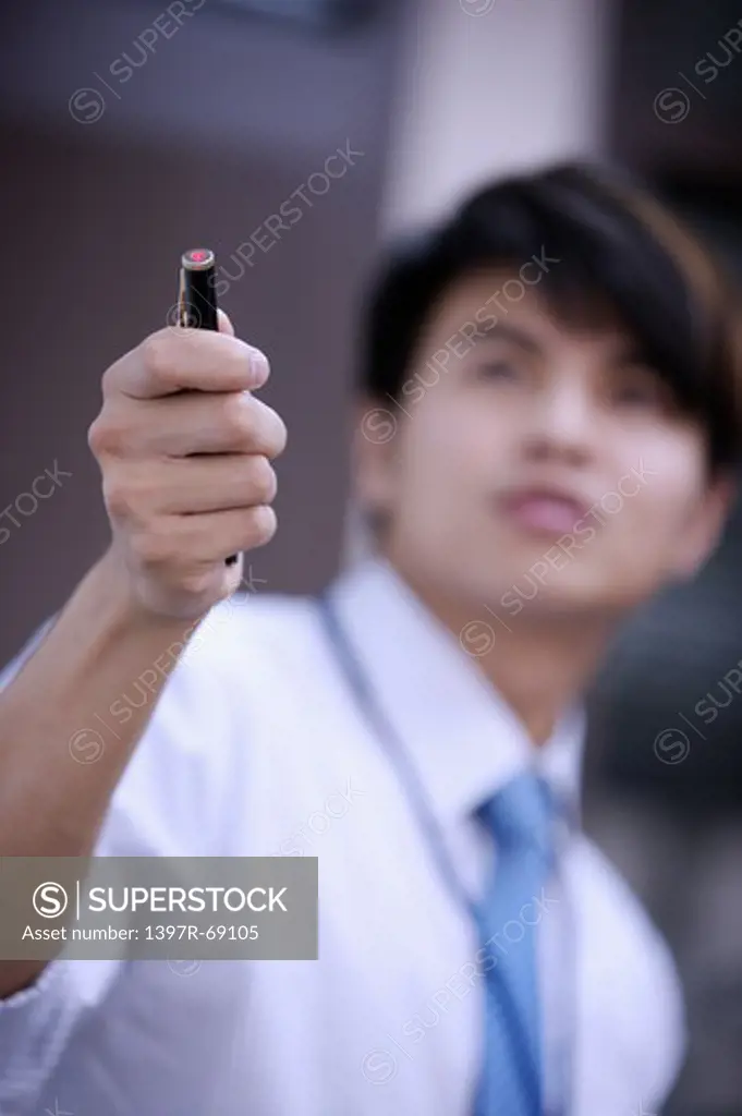 Young man holding a pen and looking up