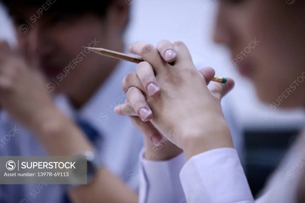 Close-up of young woman's hands holding a pencil