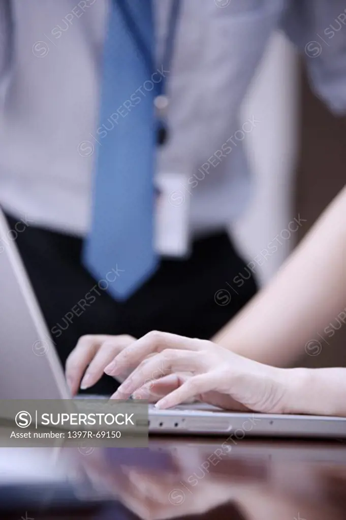 Close-up of human hands using laptop