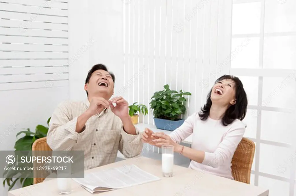 Couple, Couple sitting near the table and laughing with head back