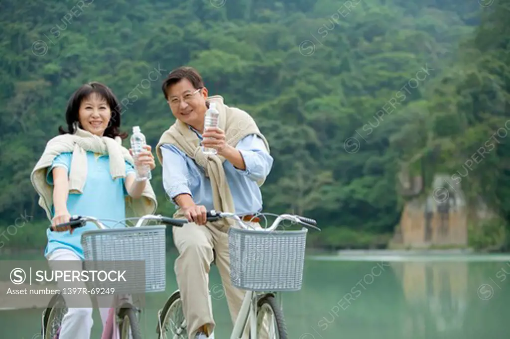 Couple, Couple riding on bike and holding a bottle water