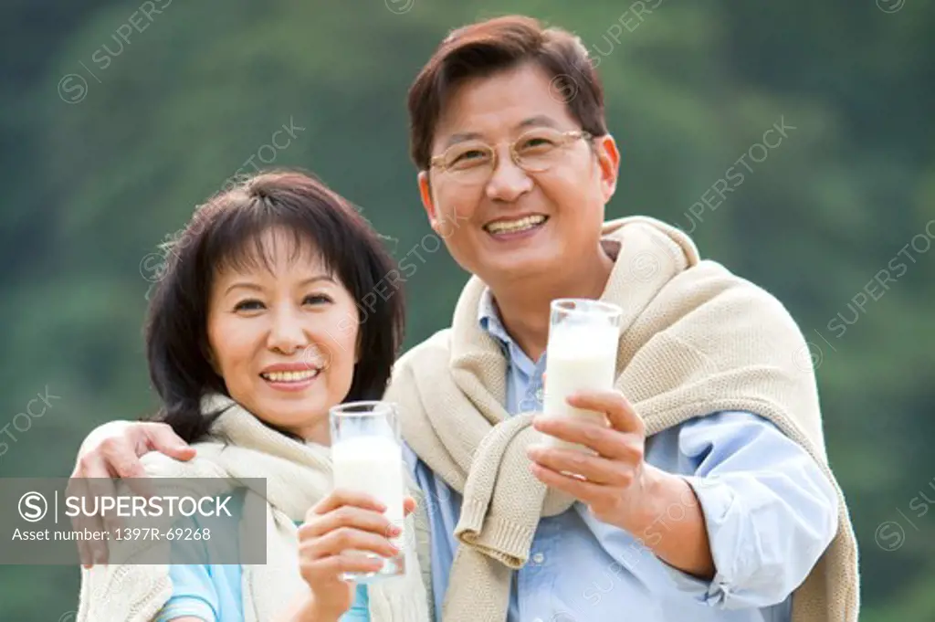 Couple, Couple holding a glass of drink and smiling at the camera