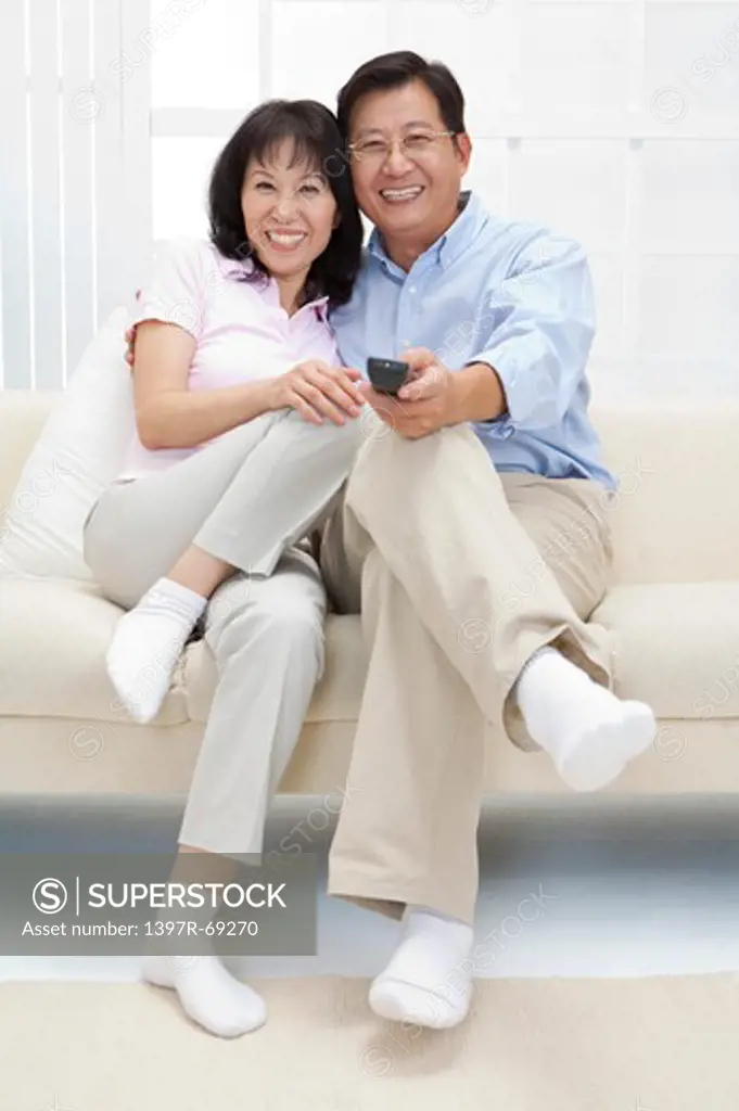 Couple, Couple sitting on sofa and smiling happily