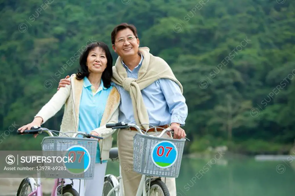 Couple, Couple holding bikes and looking up with smile