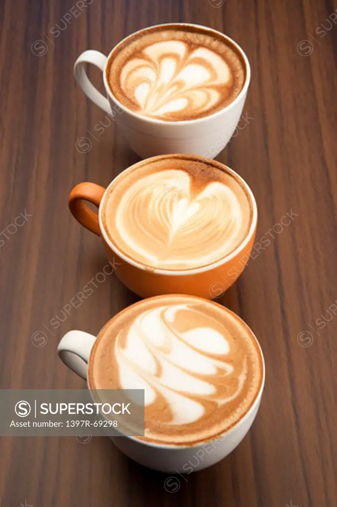 Coffee, Close-up of three cups of cappuccino with pattern on the table