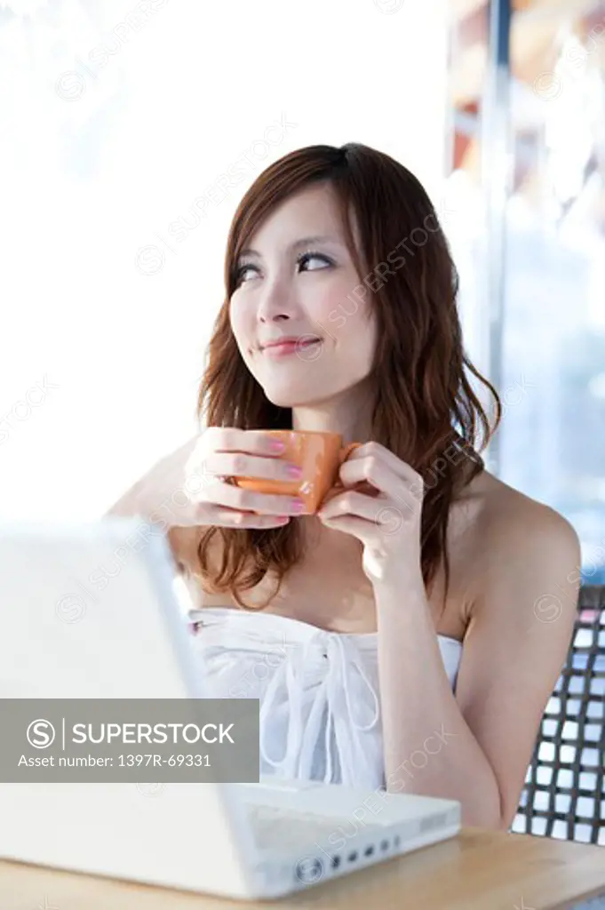 Coffee Break, Young woman holding a cup of coffee and looking away with smile