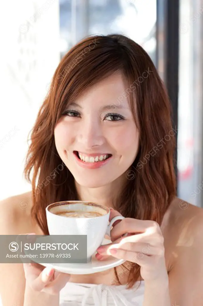 Coffee Break, Taste of Life, Young woman holding a cup of coffee and looking at the camera with smile