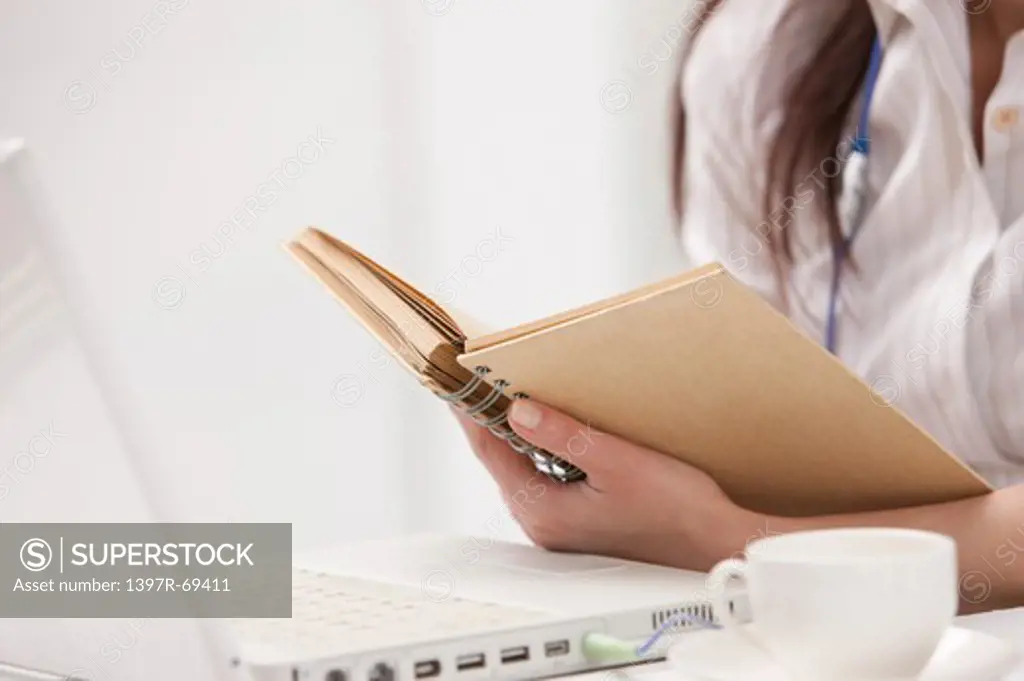 Close-up of woman holding a notebook