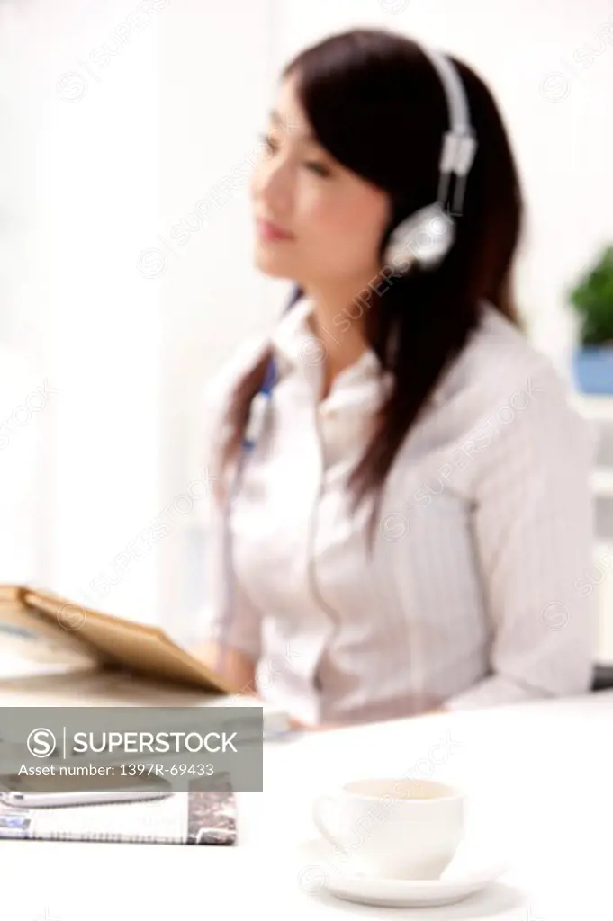 Woman holding a notebook and listening music