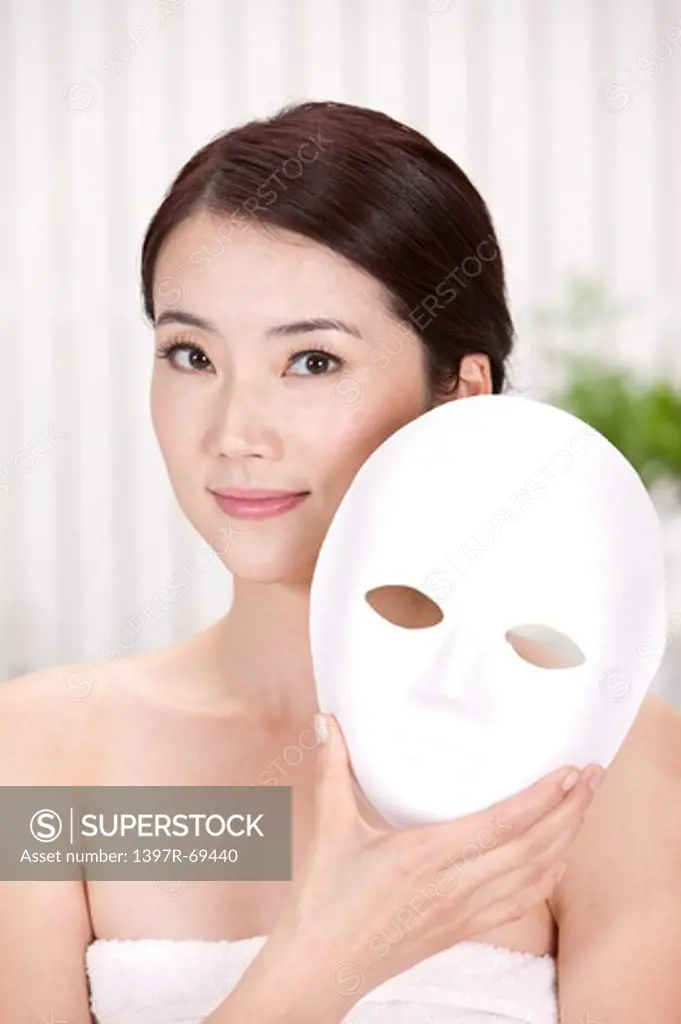 Beauty Treatment, Woman holding a mask and looking at the camera with smile