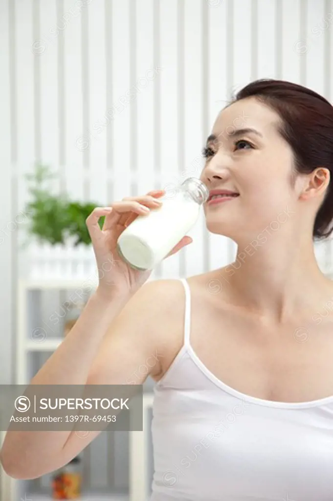 Beauty Treatment, Woman looking away and drinking a bottle of milk