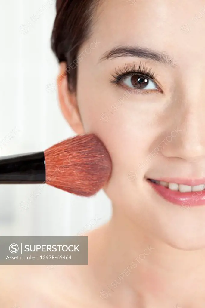 Beauty Treatment, Close-up of a blush brush on woman's half face