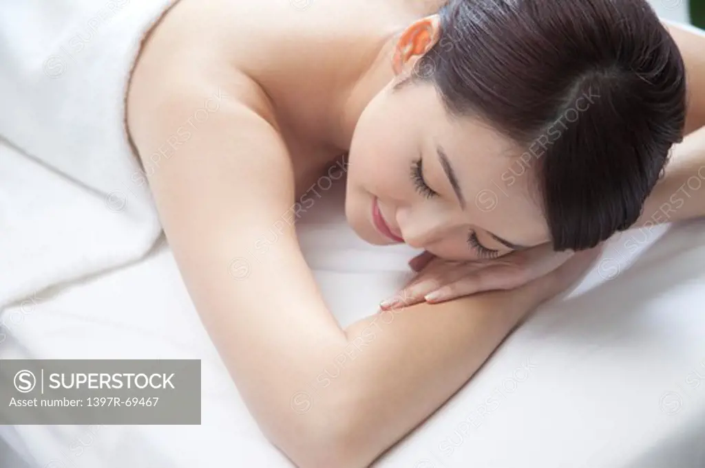 Beauty Treatment, Woman lying on front on massage table with eyes closed