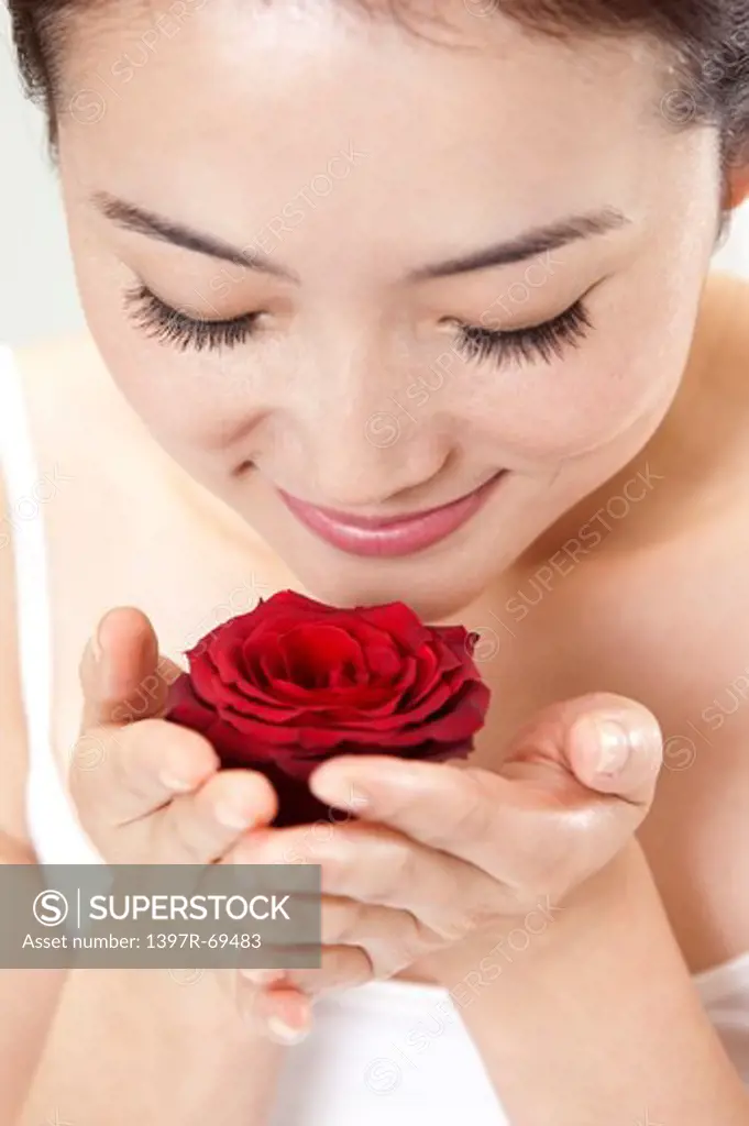 Beauty Treatment, Close-up of woman smelling a red rose with smile
