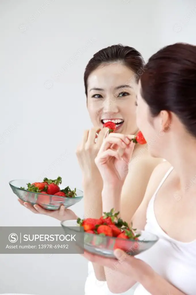 Beauty Treatment, Woman looking at the mirror and eating a plate of strawberry