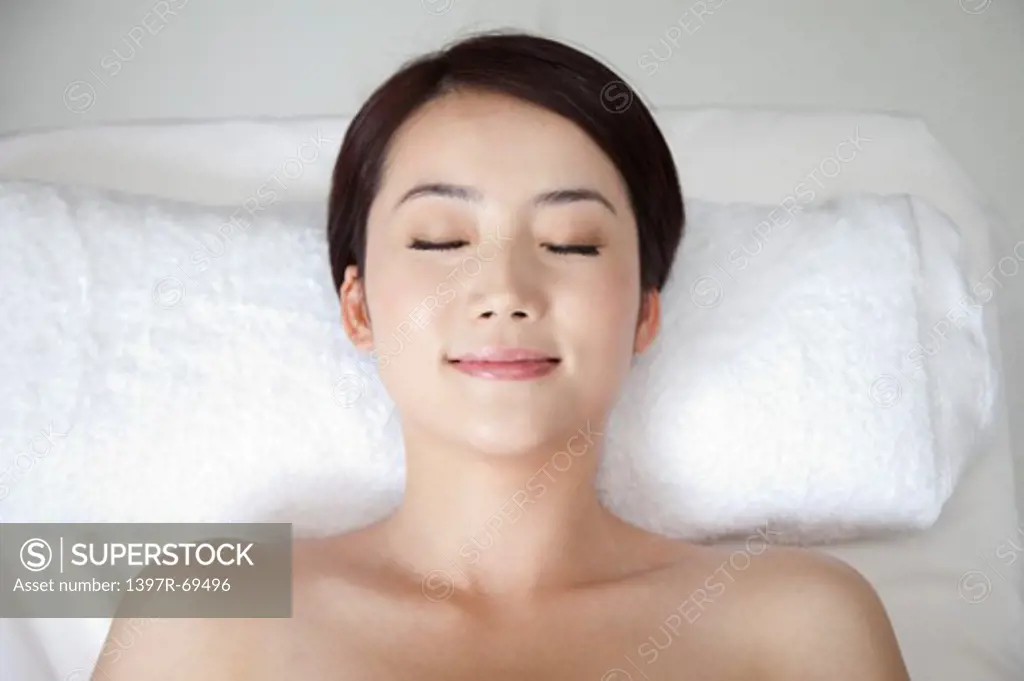 Beauty Treatment, Woman lying on massage table with eyes closed and smiling