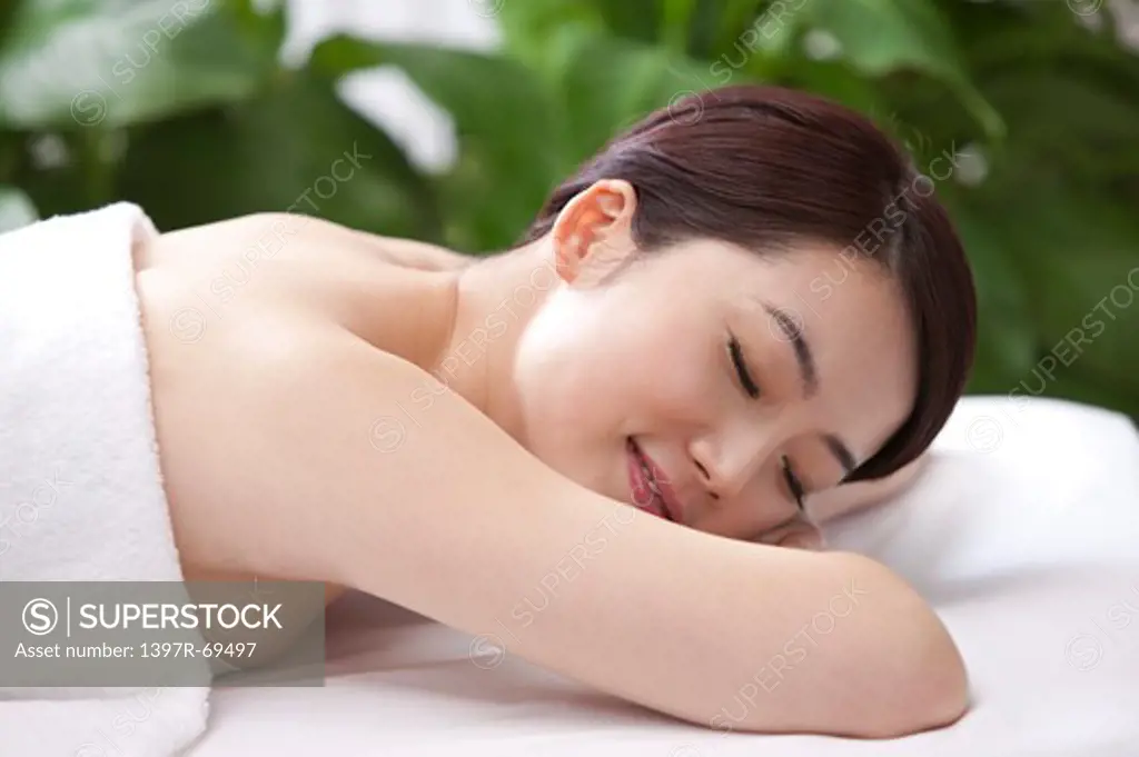 Beauty Treatment, Woman lying on front with eyes closed on massage table