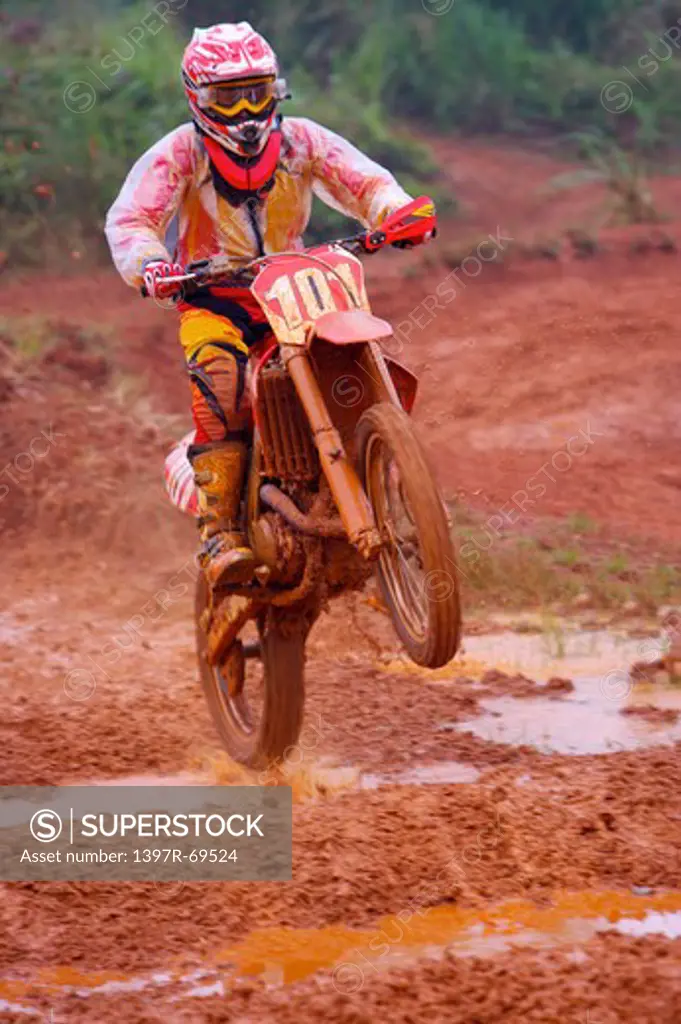 Young man motocross over field.