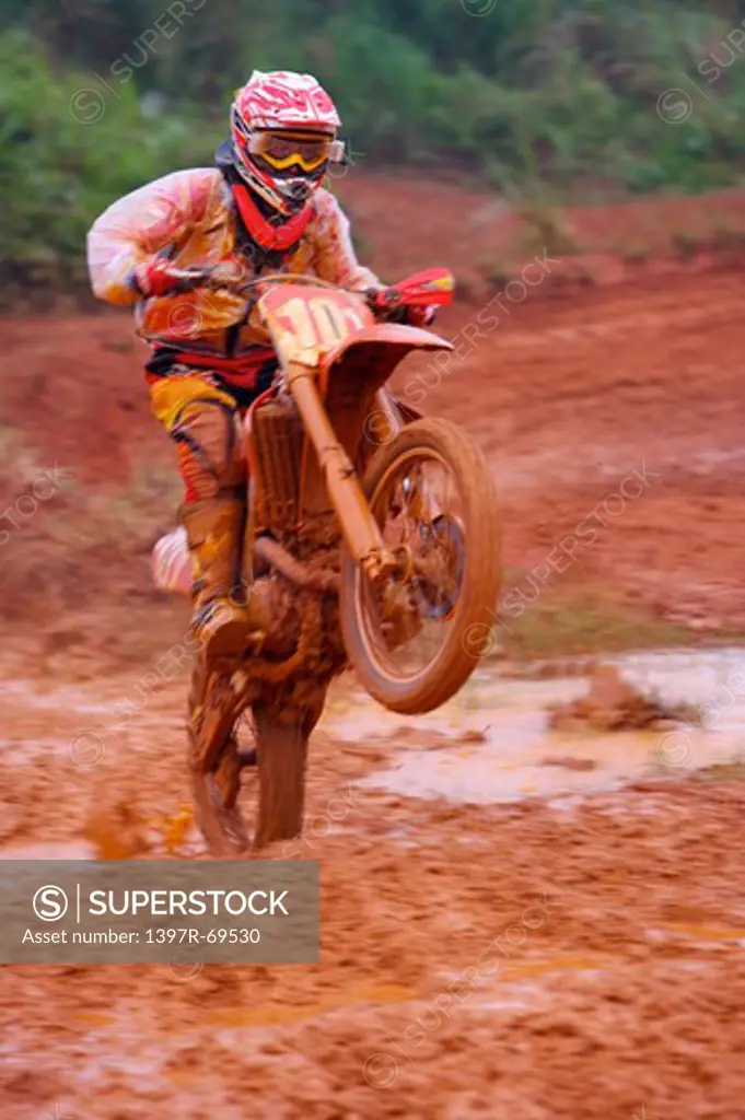 Young man motocross over field.