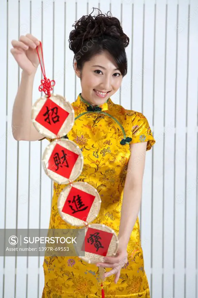 New Year, Young woman wearing Chinese traditional clothing and holding couplet with smile