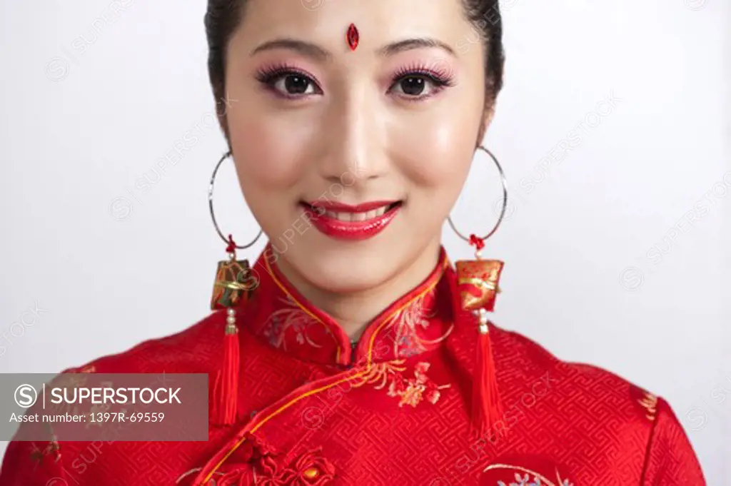New Year, Close-up of young woman wearing Chinese traditional clothing and smiling at the camera
