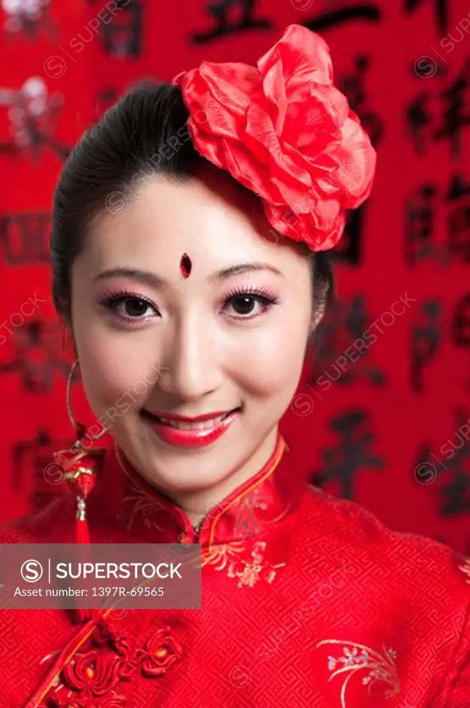 New Year, Close-up of young woman wearing Chinese traditional clothing and a red flower with smile,