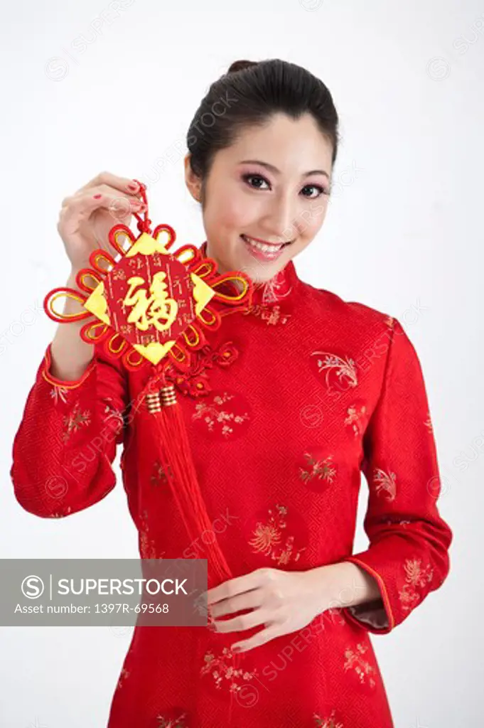 New Year, Young woman wearing Chinese traditional clothing and holding a tassel with smile