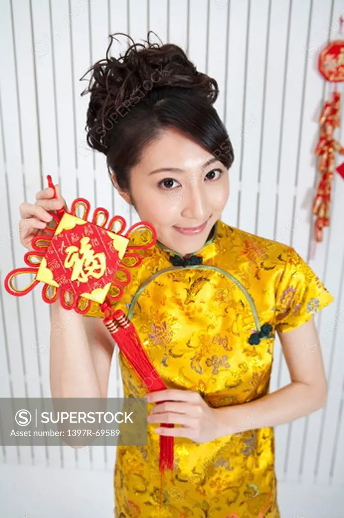 New Year, Young woman wearing Chinese traditional clothing and holding a decoration