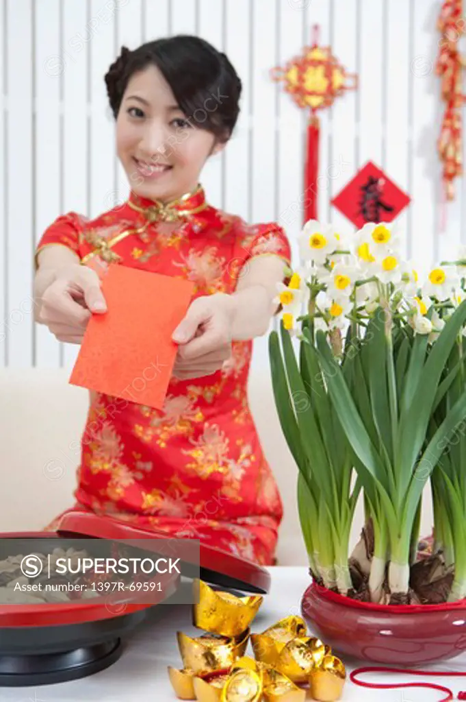 New Year, Young woman wearing Chinese traditional clothing and holding a red envelope with smile