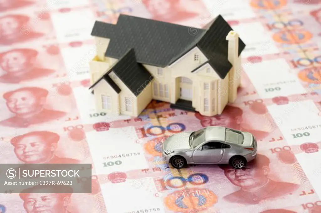 A model house and a toy car on China Currency