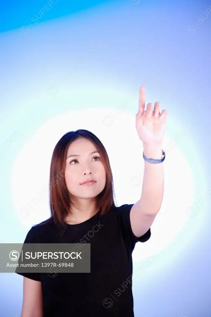 Young woman looking up and making gesture of touching