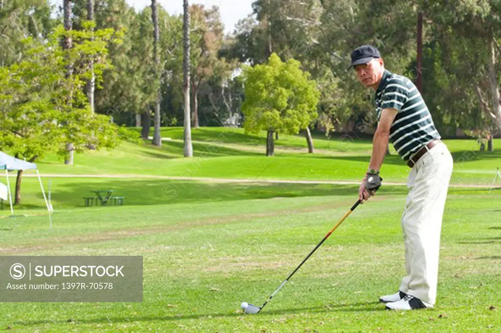 Man standing on the lawn and holding golf swing