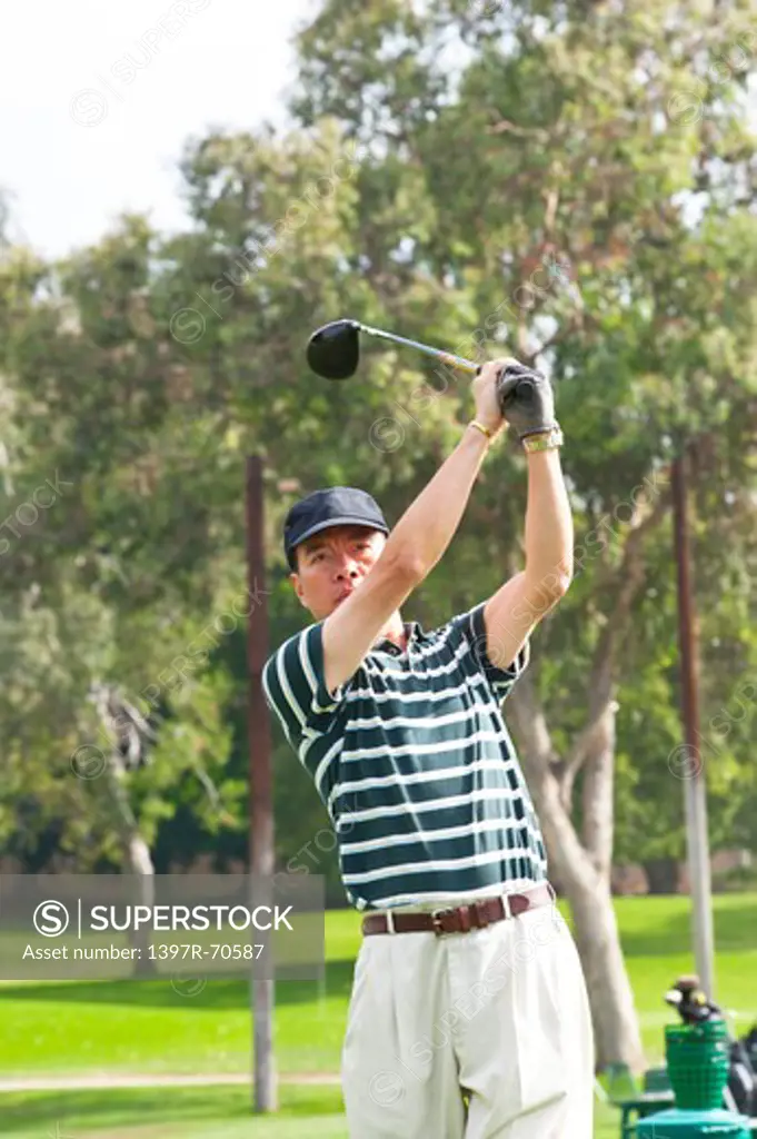 Man swinging with the golf swing and looking away