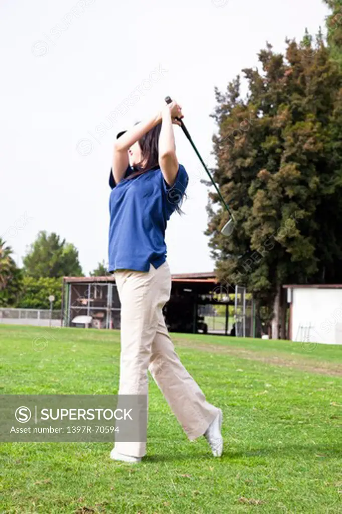 Woman holding the golf swing and swinging