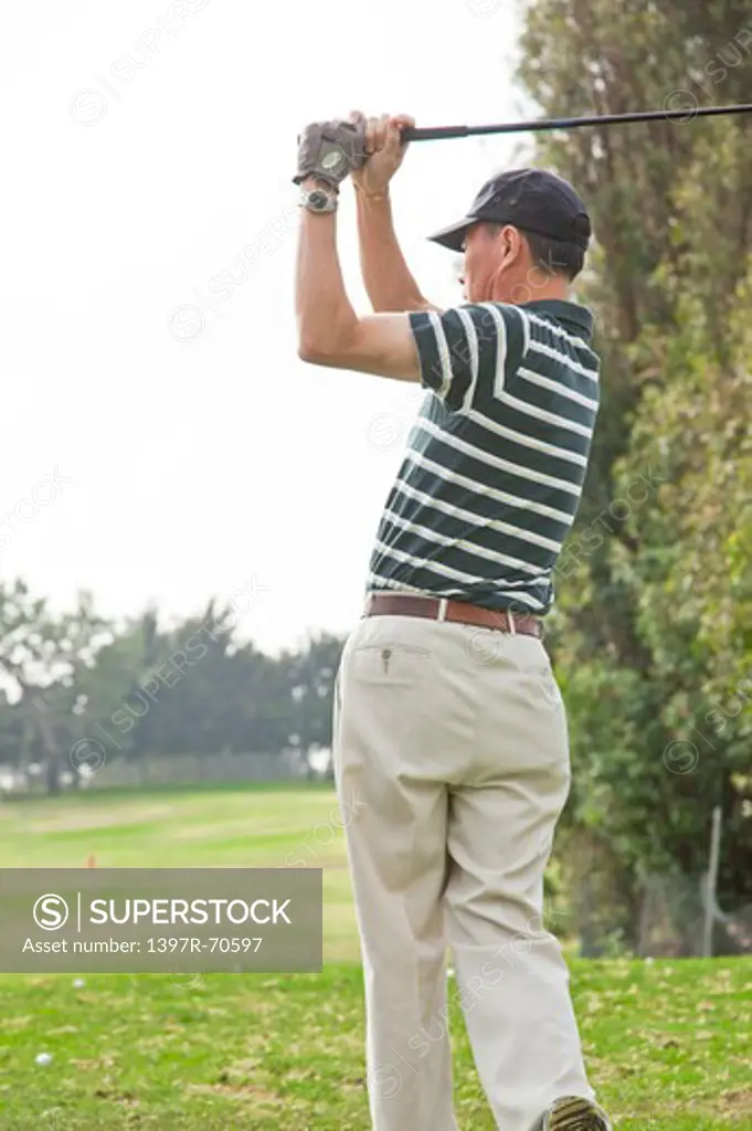 Man swinging with golf swing and looking away