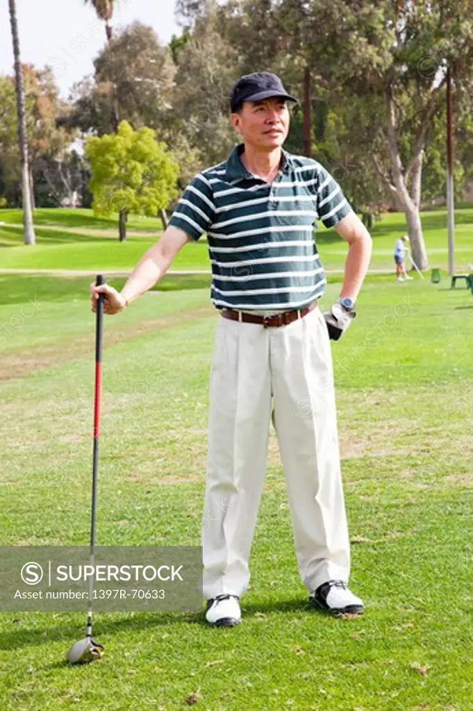 Man standing with golf swing and looking away