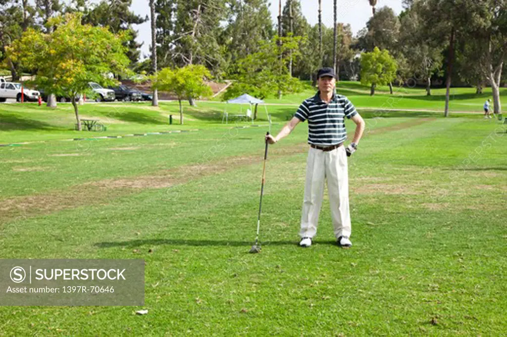 Man standing on the lawn and holding golf swing