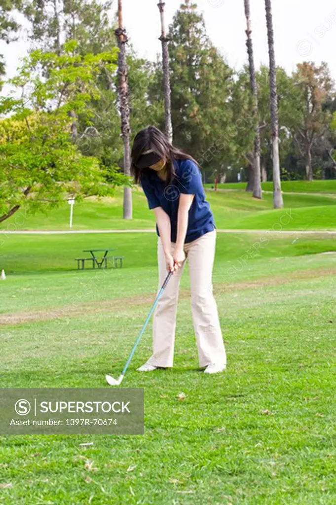 Woman holding the golf swing and looking down