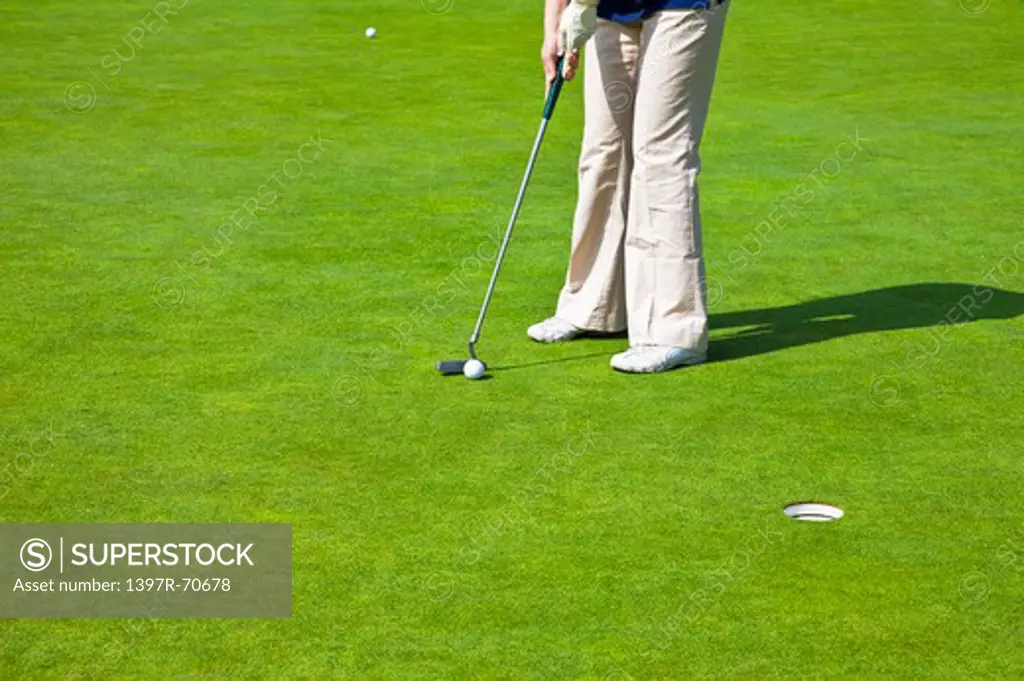 Woman holding golf swing and putting