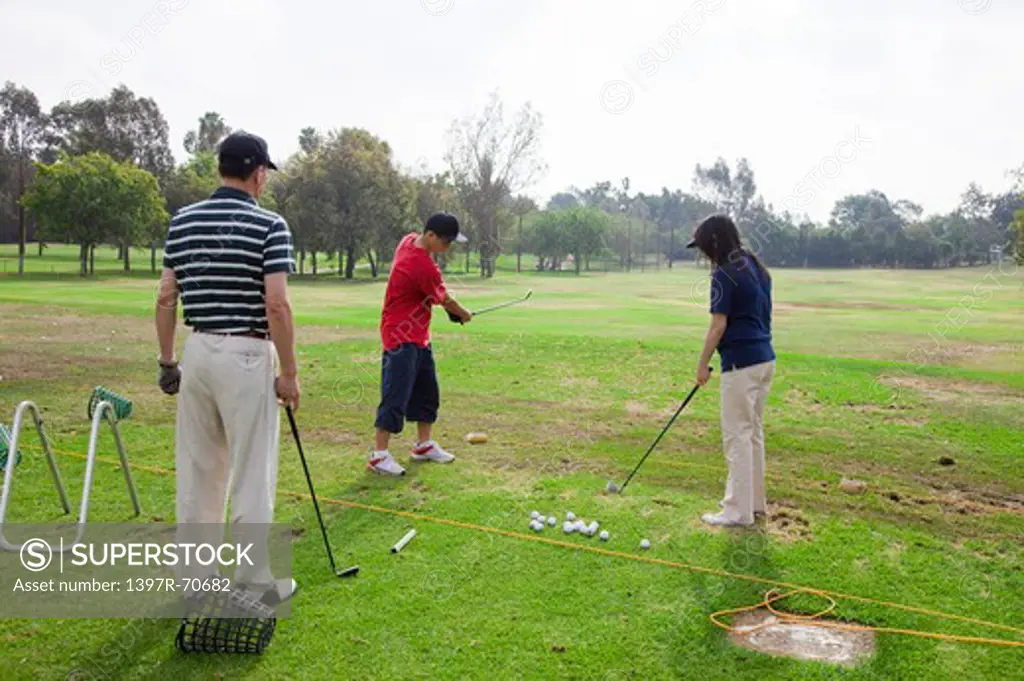 Family practicing golf on the lawn together