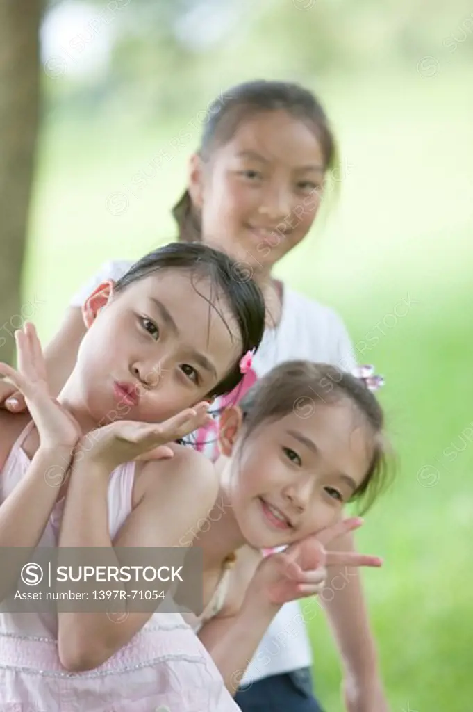 Three girls smiling at camera, gesturing