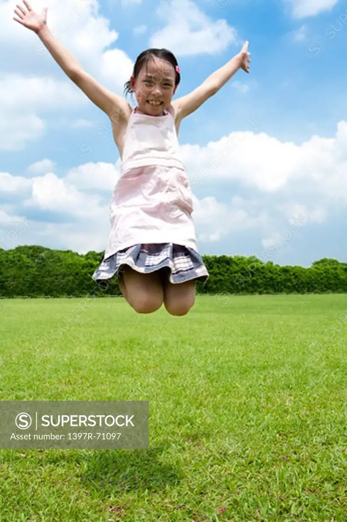 Girl jumping in mid air on lawn