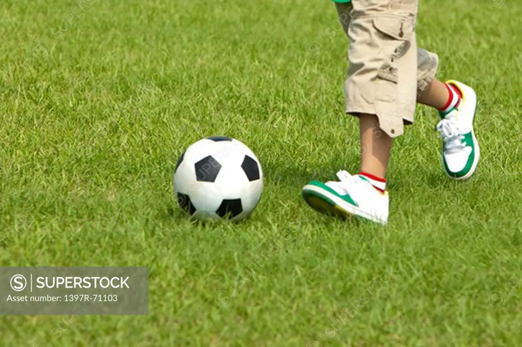 Boy playing football on lawn