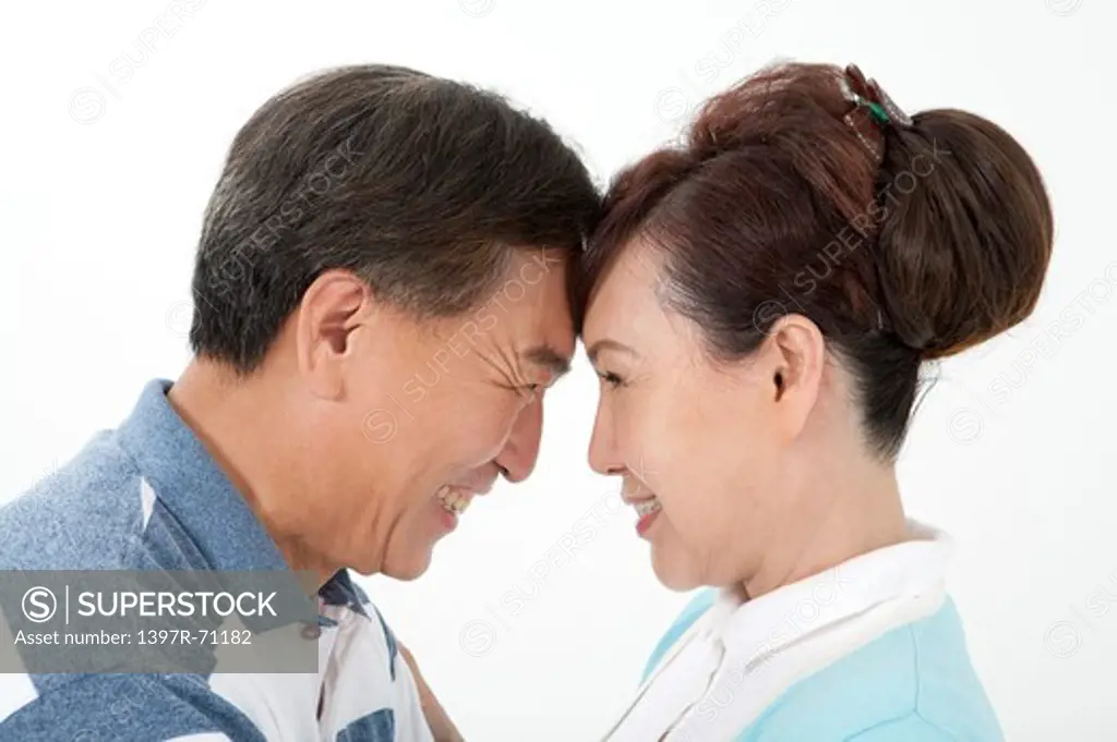 Senior couple looking into each other's eyes face to face, smiling