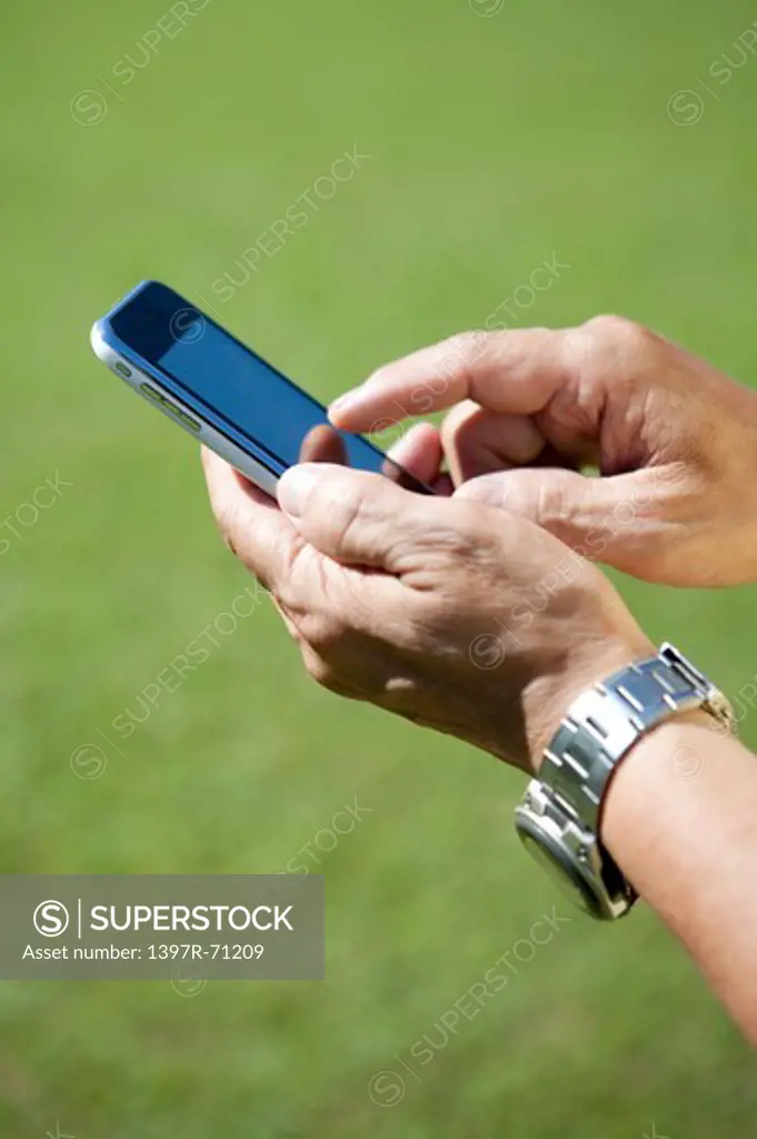 Male hands holding a cell phone and touching it's screen with finger